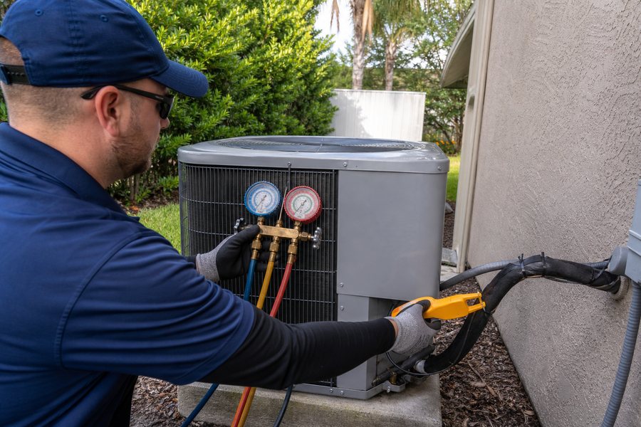 Technician checking refrigerant pressures during AC repair in Riverview